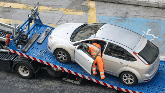 Damaged car being loaded onto tow truck. Roadside assistance concept